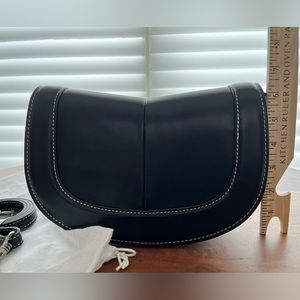 Small topstitched crossbody bag with adjustable shoulder strap in black.